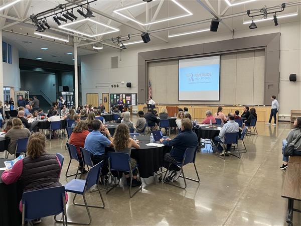 Parents sit at tables and provide feedback.